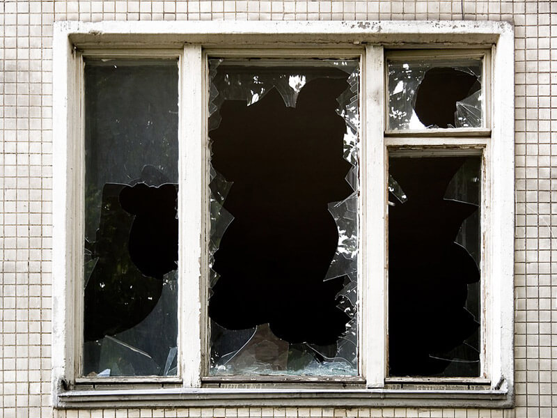 Мастер заменяет стекло в старом деревянном окне